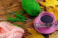 Tasse de café, aiguilles à tricoter et pelotes de laine